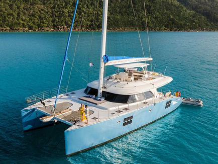 Luxury sailing catamaran cruising through crystal-clear turquoise waters