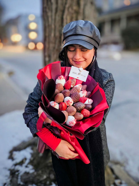 Girl holding a bouquet of strawberries chocolate wrapped in red korean paper