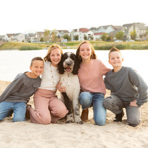 children and their dog pose for family pictures on the beach in Daybreak, Utah