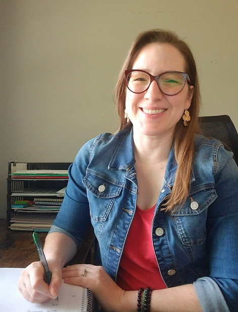 Kate Tosteson at desk writing in notebook
