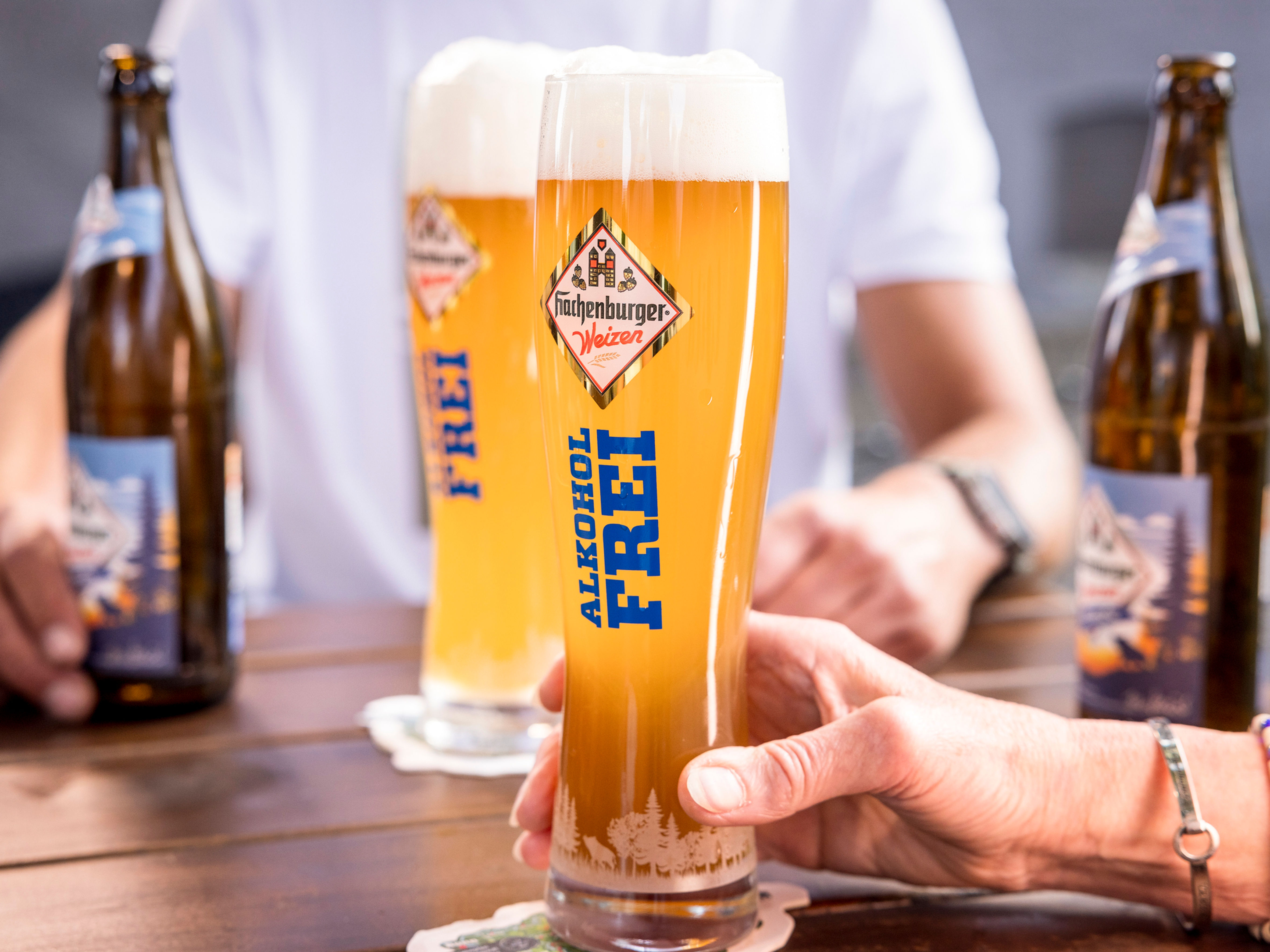 Das Bild zeigt zwei Gläser für Hachenburger Weizen Alkoholfrei. In blau tragen sie die Aufschrift "alkoholfrei". 