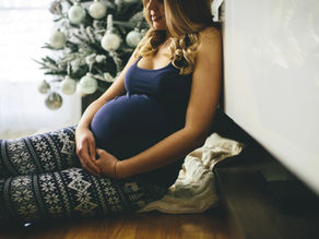 pregnant woman by christmas tree