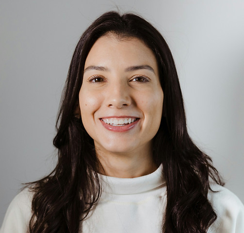 woman with black hair in a white shirt smiling