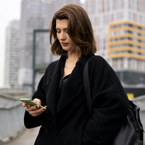 woman in the city looking down at her phone