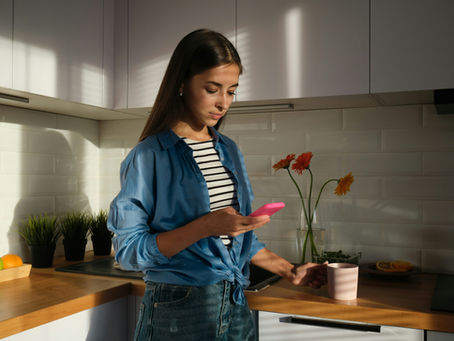 woman with brown hair looking at her phone