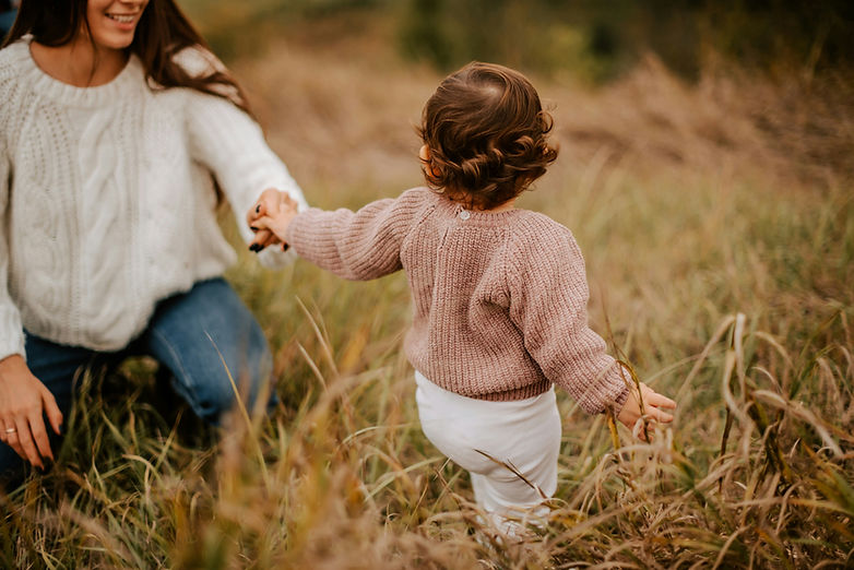 mother and child walking in field