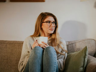 woman sitting on a couch drinking coffee