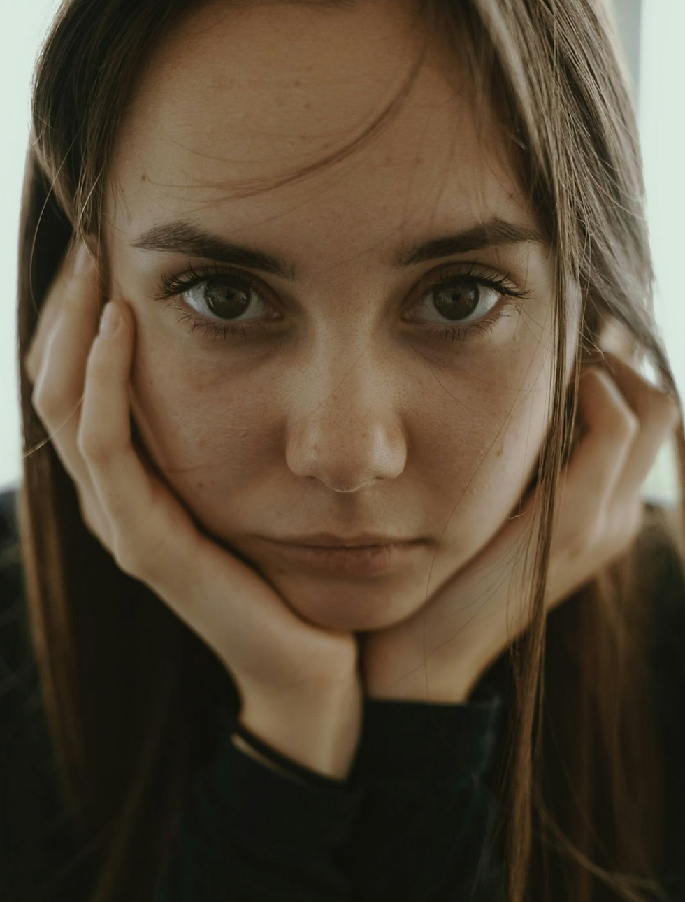 A woman standing alone in her kitchen, reflecting on her experience with an at-home abortion and the silence that followed