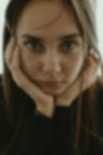 woman holding her face and looking at the camera
