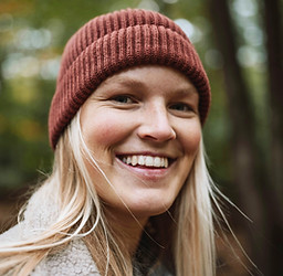 woman in forest wearing a red hat
