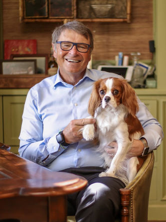 David Novak in his Palm Beach home office with his dog on his lap.