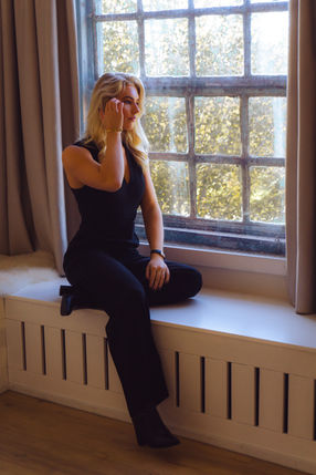 Vrouw poseert bij het raam, Portraitique Media.