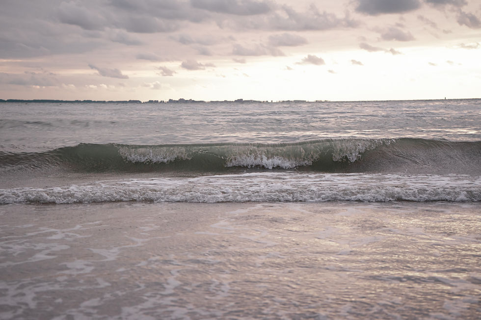 De golven van de Westerschelde die stukslaan op het kalootstrand bij Borssele tijdens de zonsondergang