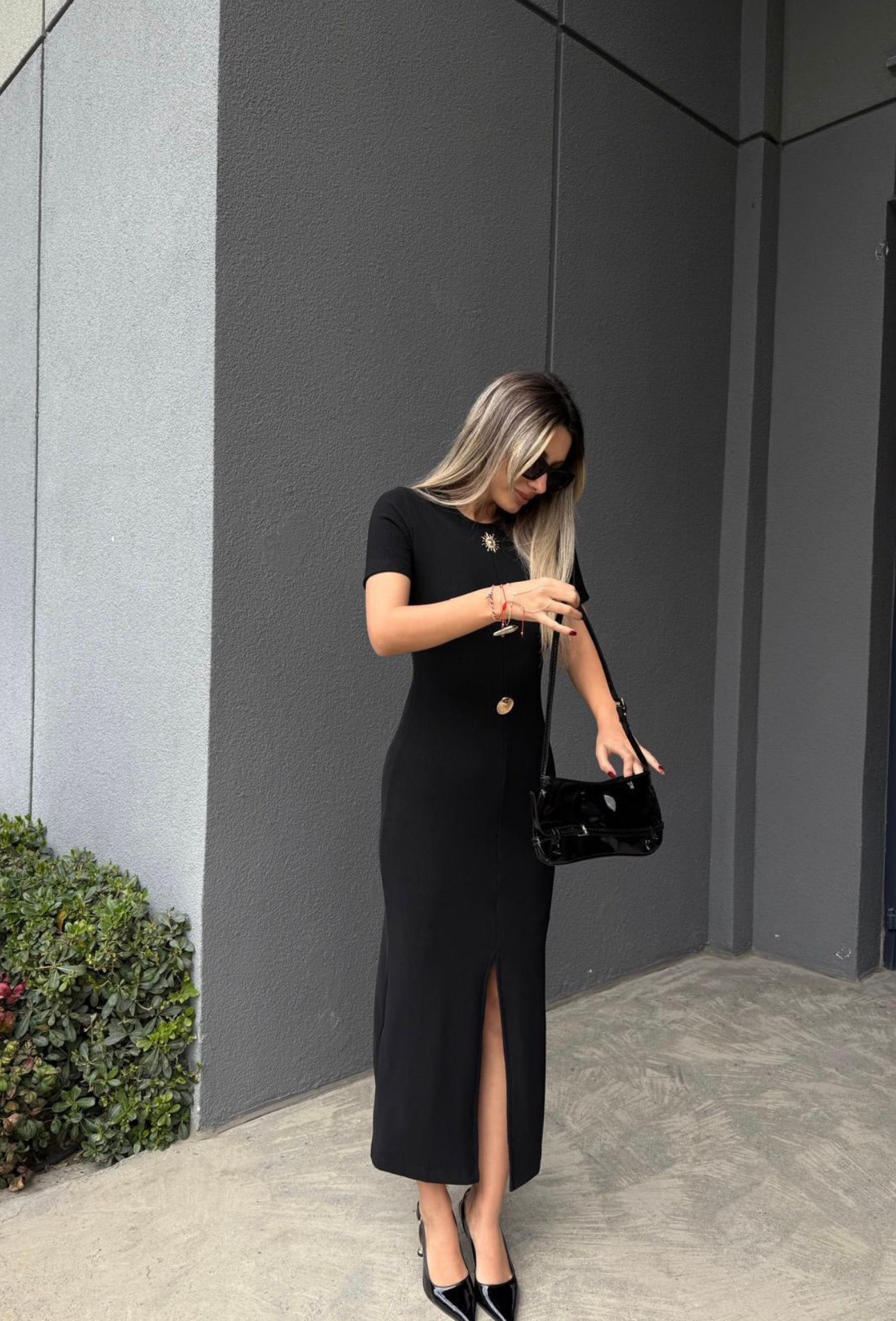 Woman in black fitted dress with handbag