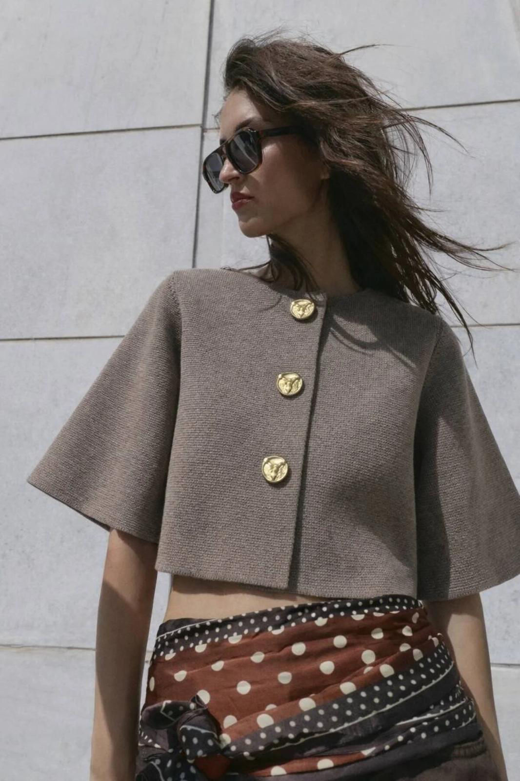 Woman in cropped jacket with gold buttons