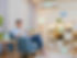asian man sitting on sofa and using smart home control app on mobile phone with augmented