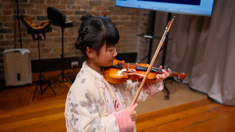 A little girl trying a violin