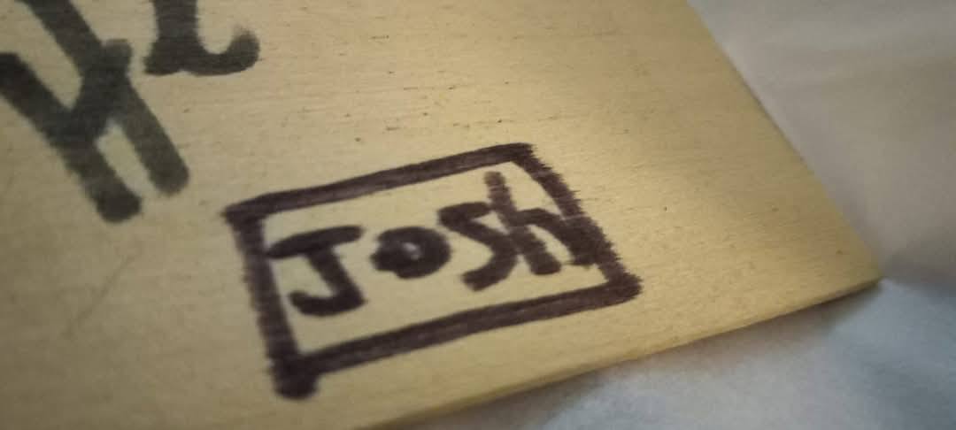 Josh wrote on a piece of wood his name in black sharpie marker inside a square