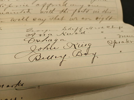 Close-up of handwritten cursive text on lined paper. Names and words like "John King" and "Billy, Boy" are visible, with sepia tone.