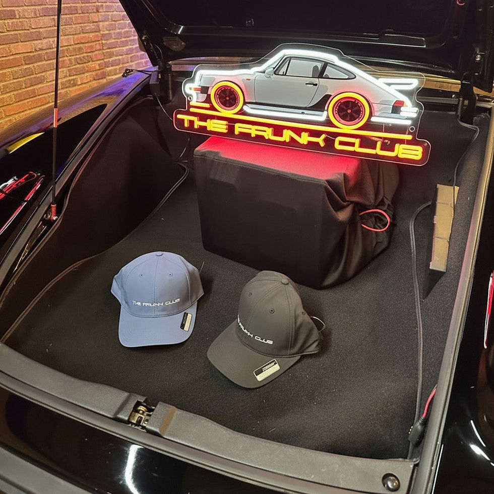 Thumbnail: Angled view of the neon sign in the trunk with a blue glow around the stylized car outline and “THE TRUNK CLUB” lettering.