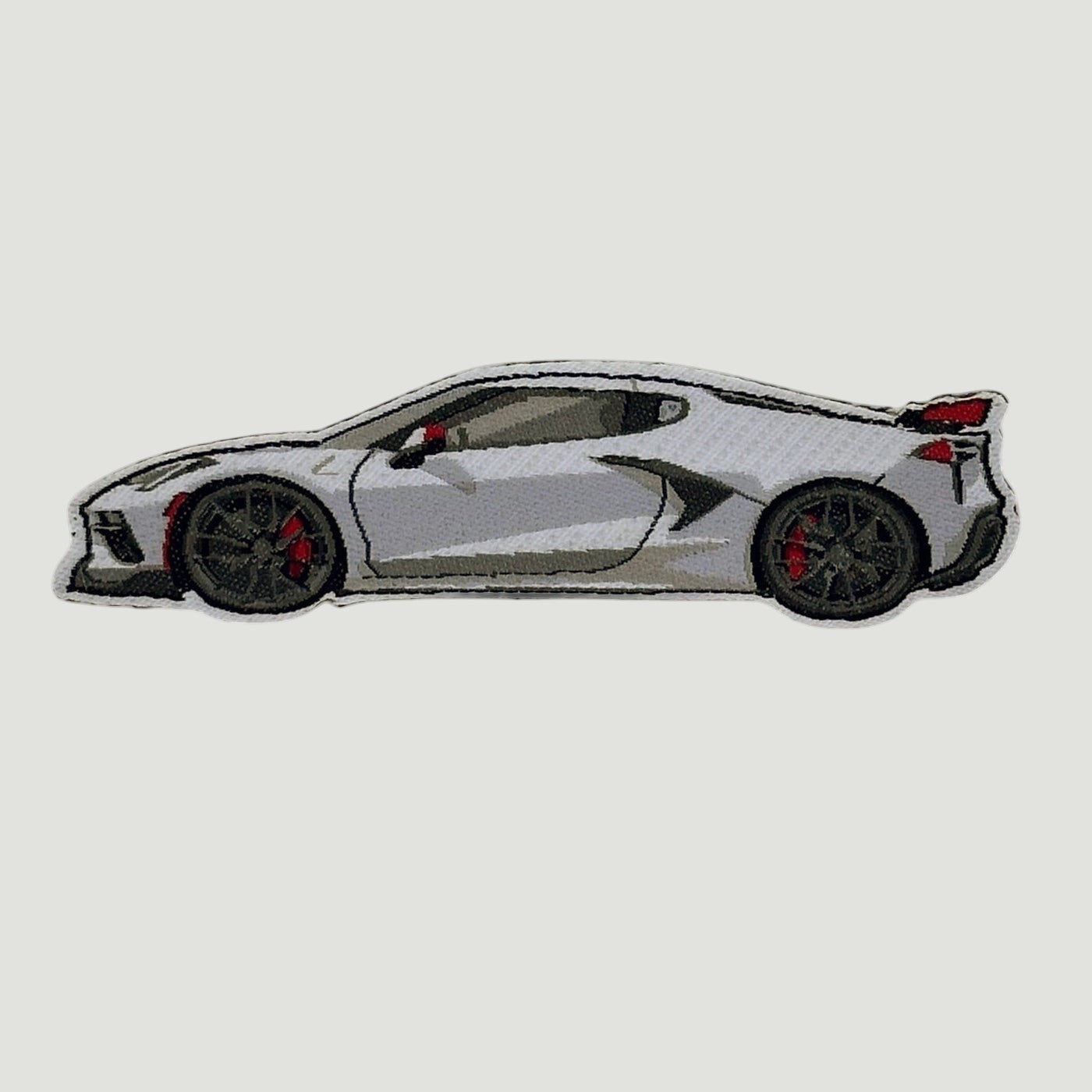 Embroidered patch showing a white Corvette C8 side profile with black and red detailing.