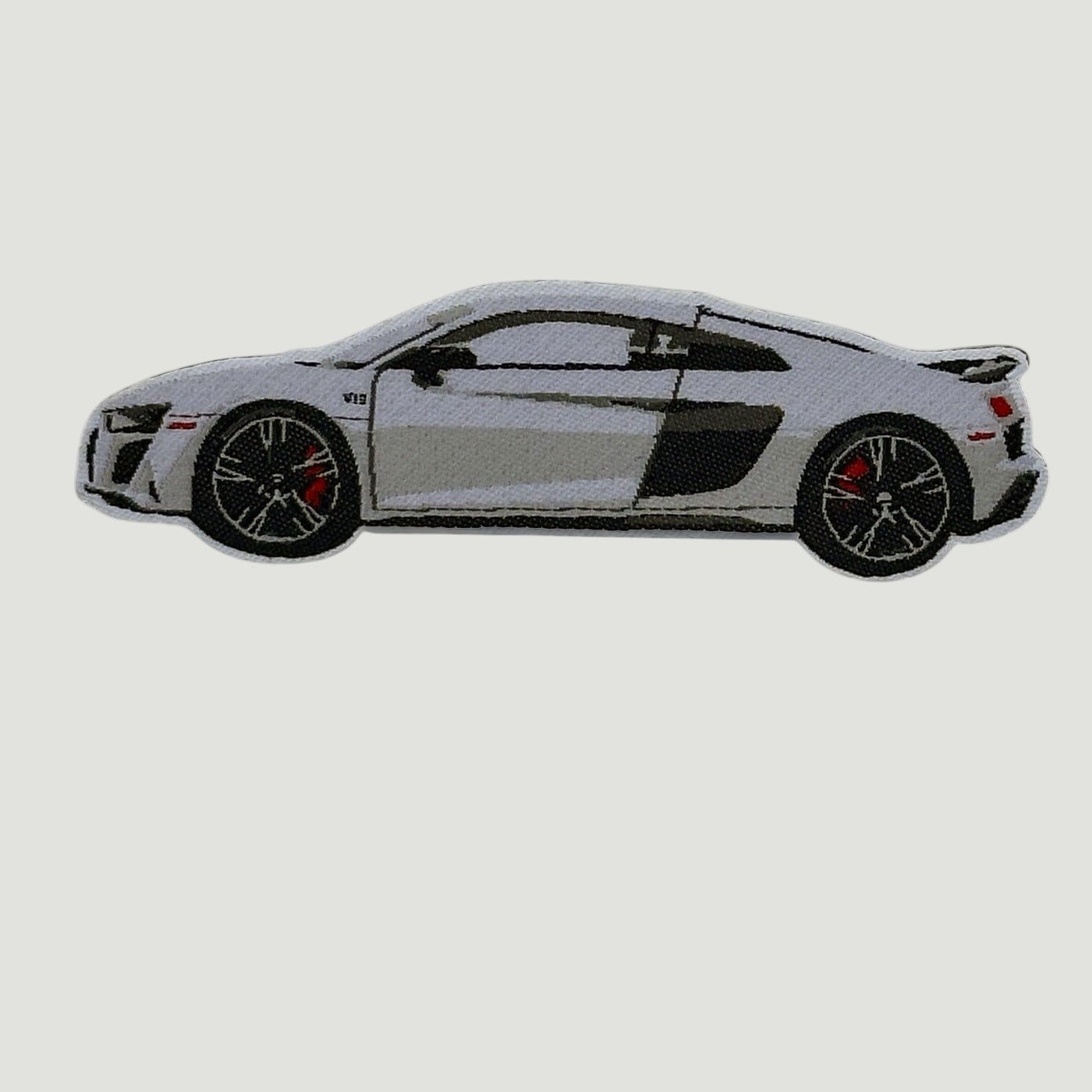Side‑profile illustration of a silver Audi R8 with black and red accents against a neutral background.