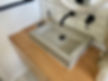 Square concrete vessel sink on modern console.