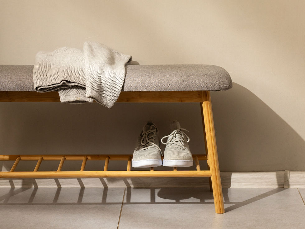 Close-up of entryway bench with a cardigan resting on top. There is storage for shoes and a restful place to pause.  