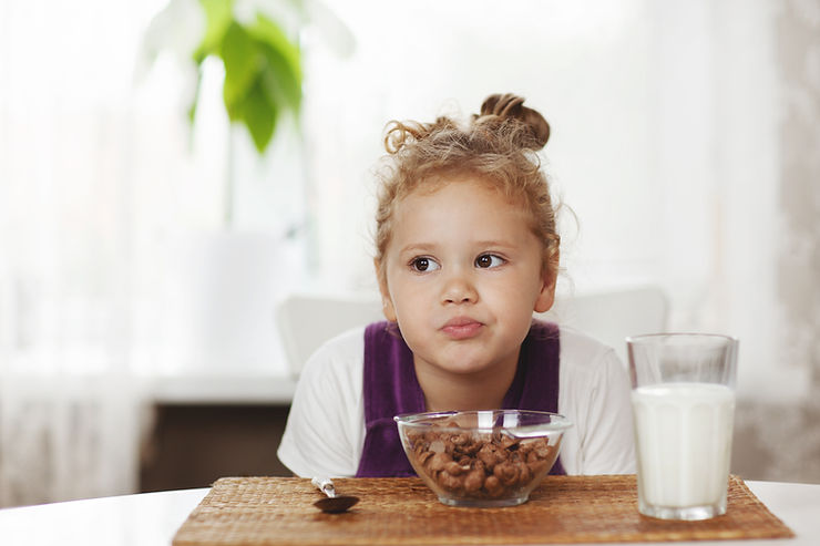 Image Alt Text:
Child at breakfast with cereal and milk, representing milk allergy treatment and food allergy evaluation in Carmel Indiana