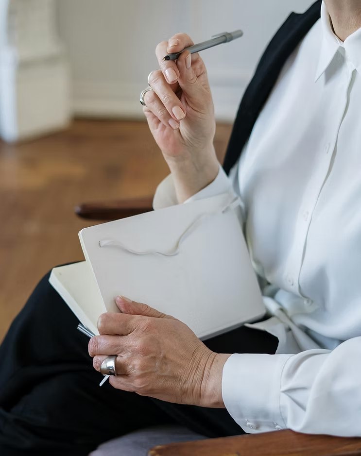 Hands holding a pen and notebook
