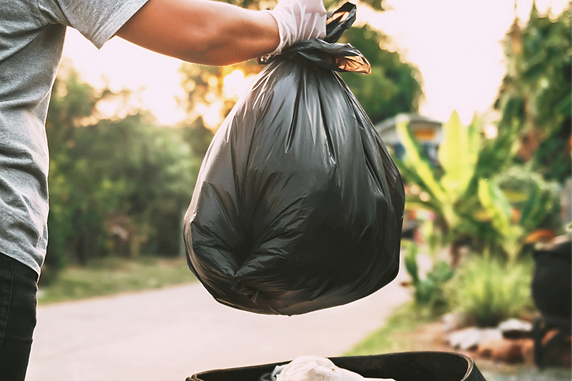 vecteezy_hand-holding-garbage-black-bag-putting-in-to-trash_7008770_844_edited.png