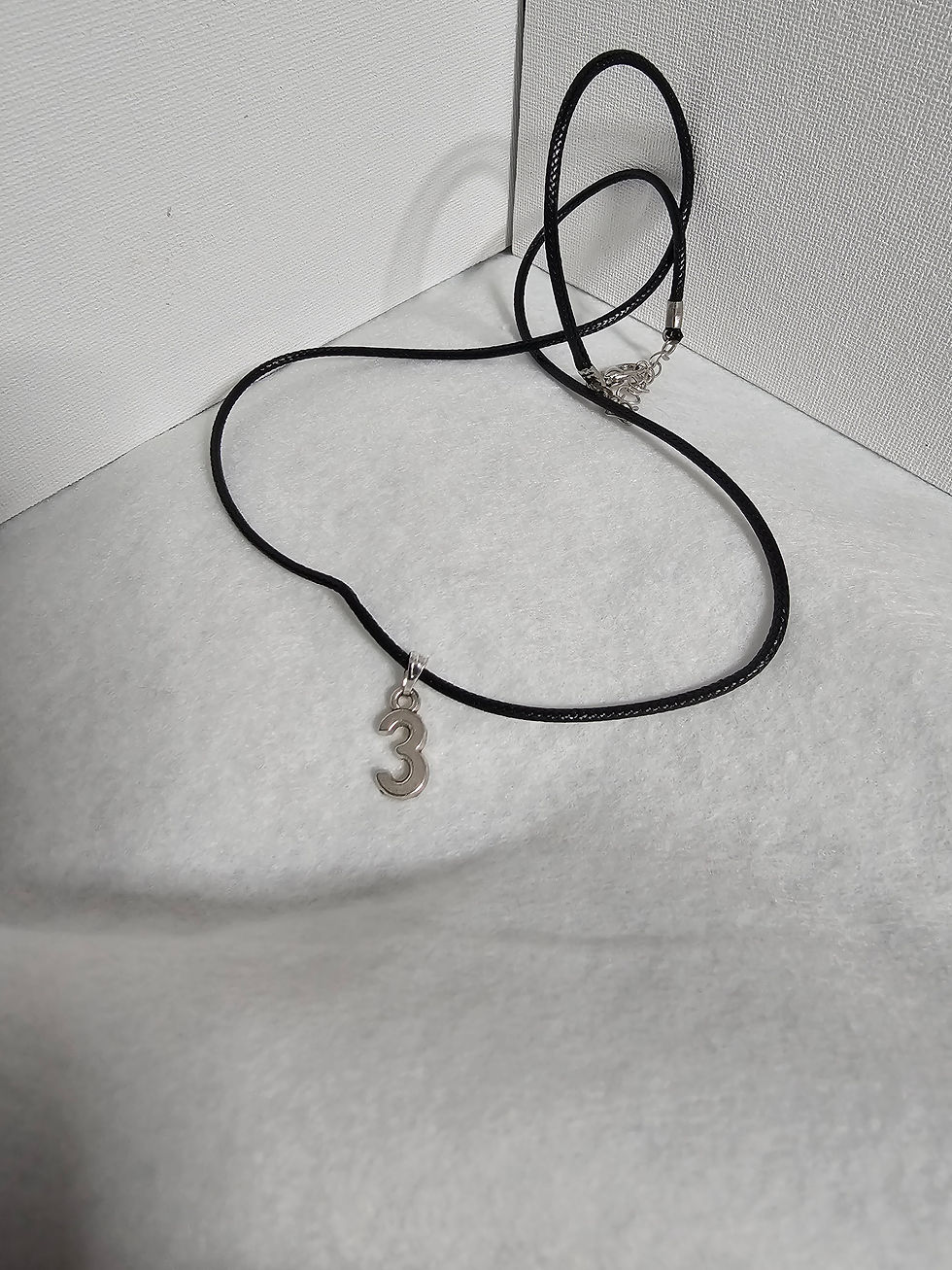 number three charm on black cord necklace
