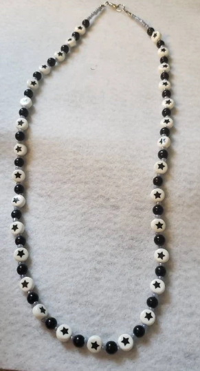 full view of necklace shown, black and white with star beads