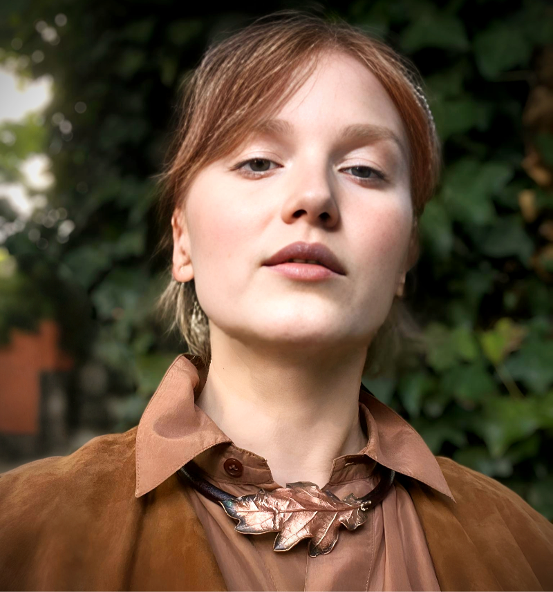 Thumbnail: girl wearing copper oak leaf necklace