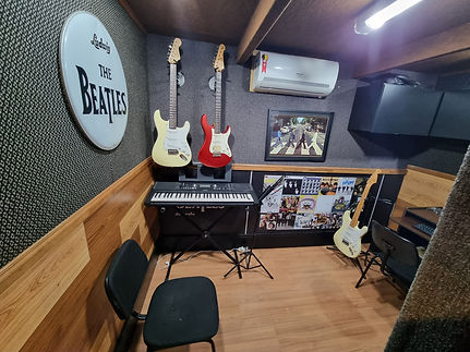 sala de aula com guitarras e um teclado