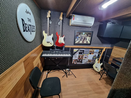 sala de aula com guitarras e um teclado