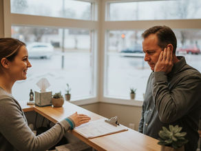 Clinic receptionist welcoming patient in ear care clinic