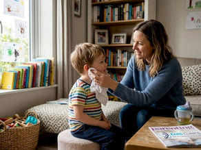 Mother gently wipes child’s ear at home