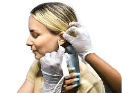 Audiologist examining child’s ear in clinic