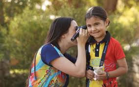 Father observing daughter's ear for symptoms