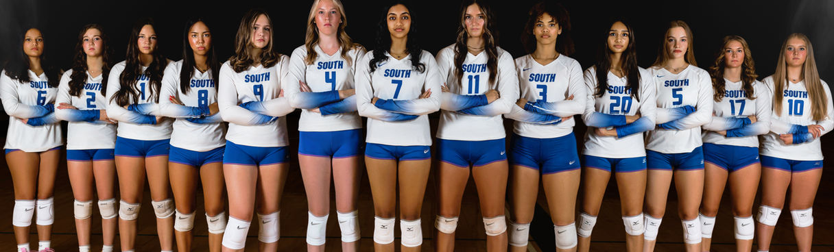 Twelve players are arranged in a horizontal line across the court. They are standing side-by-side, facing the camera, all of them have their arms crossed.
