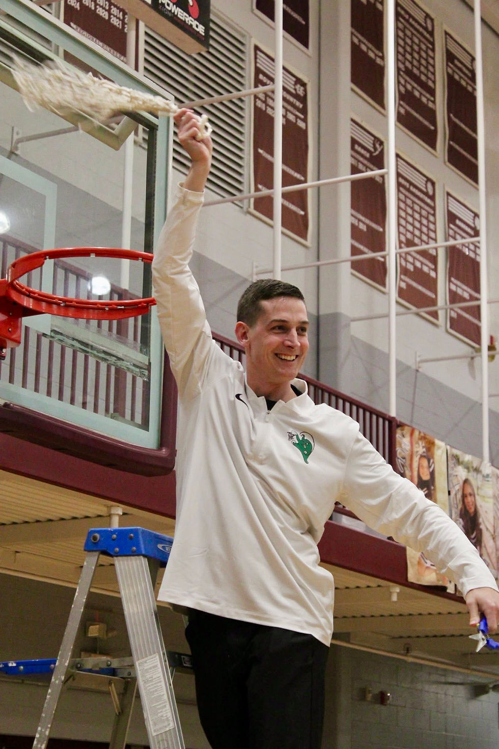 Coach Travis Hackert holds up the net after his team won the 11th District Championship in his first season as head coach. Hackert looks to coach his team to the 3rd Region title tonight against Grayson County.