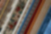 Stack of colorful wool rugs after professional deep cleaning service, showcasing restored vibrancy and freshness.