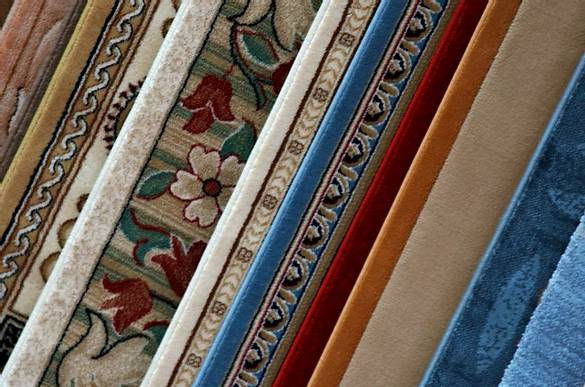 Stack of colorful wool rugs after professional deep cleaning service, showcasing restored vibrancy and freshness.