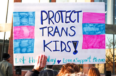 A sign saying protect trans kids, let them play, love and support them