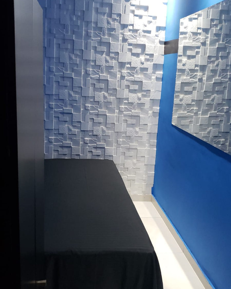 Quarto mobiliado com parede azul e cama arrumada