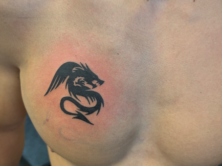 Palm-sized solid black dragon tattoo with clean lines and bold shading, symbolizing strength, protection, and mythical power in a compact design.