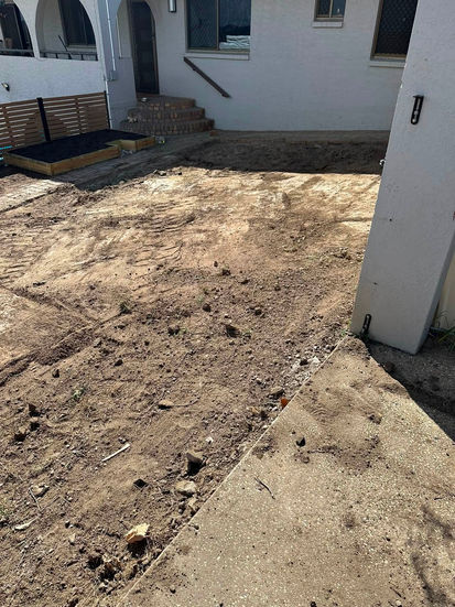 Dirt backyard prepared for turfing and landscaping.
