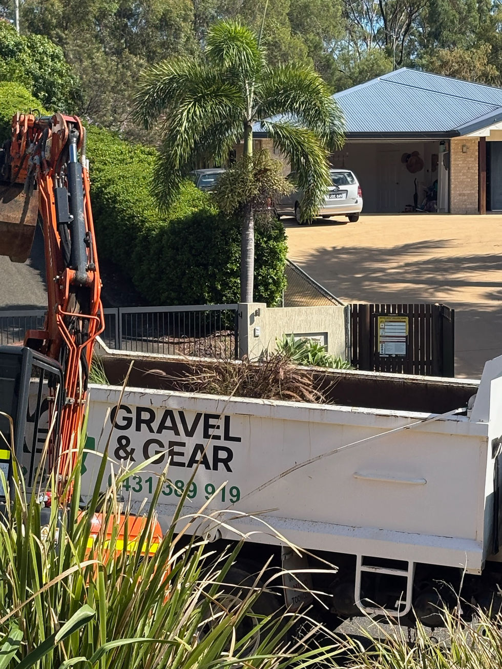 Excavator loading green waste into Gravel & Gear truck