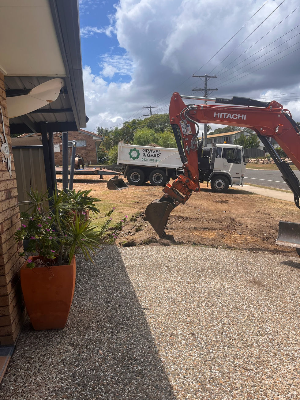 Excavator and truck at a garden removal site